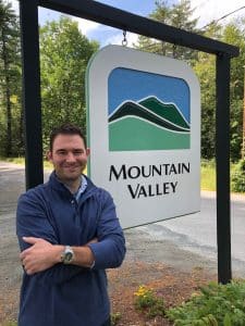 Dr. Timothy DiGiacomo, Clinical Director next to a Mountain Valley Treatment Center sign.