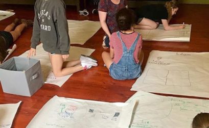 Students in expressive arts class drawing on posters